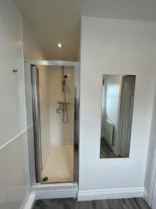 a shower in a bathroom with a mirror at Seaham Sea View 2 bedroom apartment in Seaham