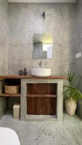 y baño con lavabo y espejo. en Twin Palms Surfhouse en Thulusdhoo