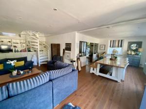 ein Wohnzimmer mit einem blauen Sofa und einem Tisch in der Unterkunft Donvillaise 15 pers : jacuzzi, 8 min à pied plage in Donville-les-Bains