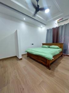 Schlafzimmer mit einem Bett und einem Deckenventilator in der Unterkunft THE GREEN CONDO in Elmina