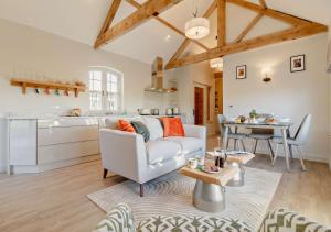 a living room with a couch and a table at The Domini Cowshed at Village Farm in Market Weston