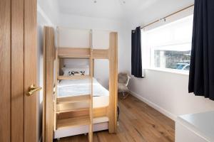 a small room with a bunk bed with a window at East Lodge, Home Farm in Belford