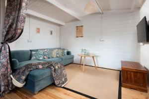 a living room with a blue couch and a table at East Lodge, Home Farm in Belford
