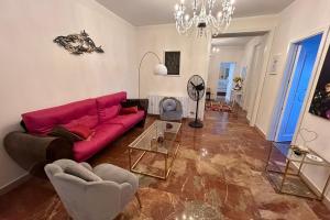 a living room with a red couch and a chandelier at Calabre - Lamezia Terme 2bdr in Lamezia Terme
