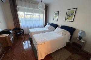 een hotelkamer met 2 bedden en een raam bij Calabre - Lamezia Terme 2bdr in Lamezia Terme