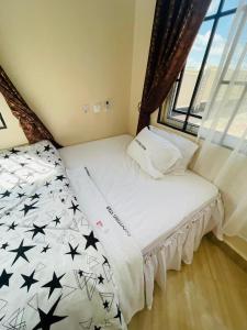sypialnia z łóżkiem z czarnymi gwiazdami w obiekcie Shooting star Lodge w Dodomie