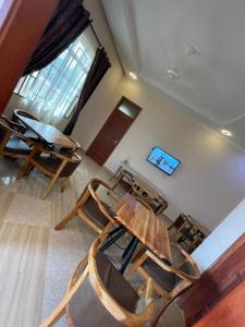 - une table et des chaises dans une chambre avec fenêtre dans l'établissement Shooting star Lodge, à Dodoma