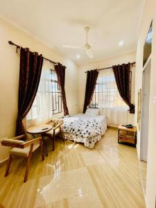 una camera con letto, tavolo e finestre di Shooting star Lodge a Dodoma