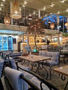 a restaurant with tables and chairs and a tree at Vromos Guest Rooms in Chernomorets