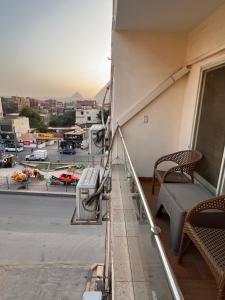 een balkon met een bank en uitzicht op de stad bij Sphinx and Pyramids INN in Caïro