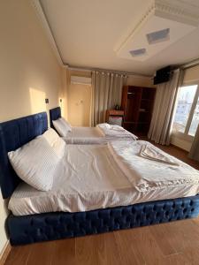 a large bed in a room with a blue frame at Sphinx and Pyramids INN in Cairo