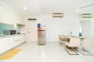 eine Küche mit einem Kühlschrank aus Edelstahl und einem Tisch in der Unterkunft Teega Creamy INS Muji 2BR 6 pax w Balcony by Our Stay in Nusajaya