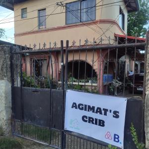 un cartel en una puerta delante de una casa en Agimats Crib Palawan en Puerto Princesa