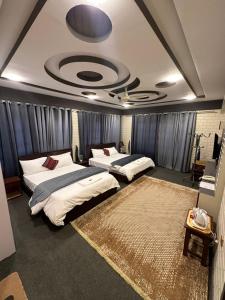 a room with three beds and a ceiling at Signature Skardu Hotel in Skardu
