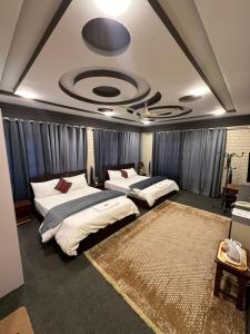 Signature Skardu Hotel في سكردو: سريرين في غرفة ذات سقف
