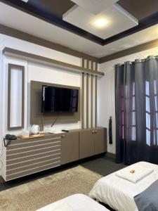 a bedroom with a tv on a dresser with a bed at Signature Skardu Hotel in Skardu