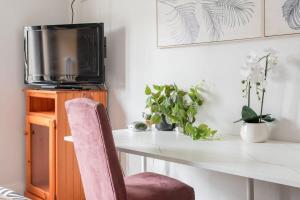 a room with a desk with a chair and a tv at Private Ensuite Queen room near Sydney Airport in Sydney