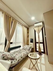 a living room with a bed and a window at Vanilla One Residence Apartment Batam in Batam Center