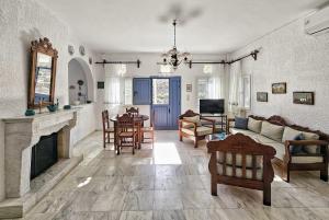 - un salon avec un canapé et une cheminée dans l'établissement Tinoshomelidays Residences, à Venardatos