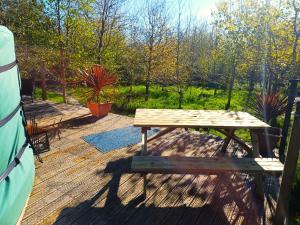 a wooden picnic table sitting on top of a deck at The Yurt in Cornish woods a Glamping experience in Penzance