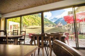 a restaurant with tables and chairs and a large window at Auberge du Mont Blanc in Trient
