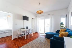 a living room with a blue couch and a table at Beach House Cascais in Estoril