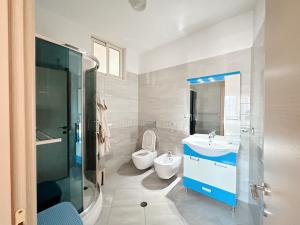 une salle de bain avec un lavabo, des toilettes et une douche dans l'établissement Tirana Family Suite, à Kashari