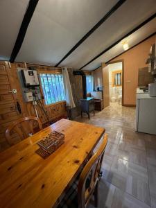 ein Esszimmer mit einem Holztisch und einer Küche in der Unterkunft Cabaña ecologica del lago in Paredes de Buitrago