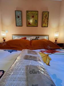 1 dormitorio con 1 cama grande con almohadas de color naranja en Cabaña ecologica del lago, en Paredes de Buitrago