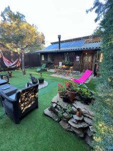 einen Hinterhof mit einer Terrasse mit Stühlen und Pflanzen in der Unterkunft Cabaña ecologica del lago in Paredes de Buitrago