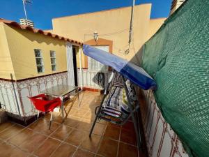 een blauwe paraplu op het hek van een huis bij Casa 4 habitaciones, 5 personas in Puerto de Mazarrón