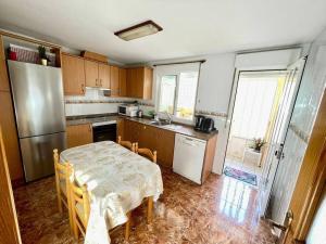 een kleine keuken met een tafel en een koelkast bij Casa 4 habitaciones, 5 personas in Puerto de Mazarrón