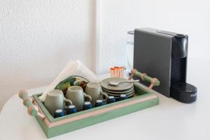 a tray with cups and plates next to a printer at Beach House Cascais in Estoril