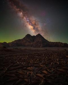 a starry night in the desert with a mountain at Star World Camp in Wadi Rum
