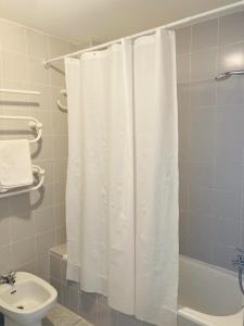 a bathroom with a white shower curtain and a sink at Holiday Home La Atalaya de Conil in Conil de la Frontera