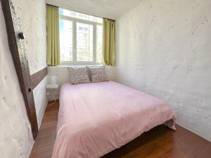 een kleine slaapkamer met een roze bed en een raam bij Spacieux appartement en centre-ville des Sables - 6 pers in Les Sables-dʼOlonne