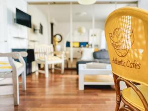 een woonkamer met witte stoelen en een bank bij Spacieux appartement en centre-ville des Sables - 6 pers in Les Sables-dʼOlonne