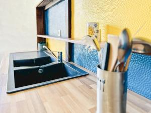 een aanrecht met een wastafel en een kopje keukengerei bij Spacieux appartement en centre-ville des Sables - 6 pers in Les Sables-dʼOlonne