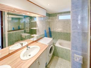 een badkamer met 2 wastafels, een bad en een wastafel bij Spacieux appartement en centre-ville des Sables - 6 pers in Les Sables-dʼOlonne +4 foto's