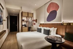 a bedroom with a large bed and a table at Citadines Connect City Centre Singapore in Singapore
