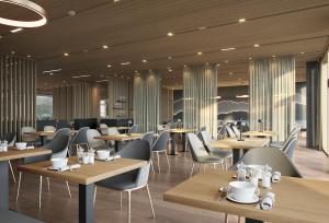 メラウにあるSonne Mellau - Feel good Hotelの木製のテーブルと椅子のあるレストラン、カフェテリア