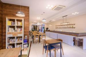 a restaurant with tables and chairs and books at Pine Hill Hotel in Seogwipo