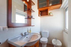 a bathroom with a sink and a toilet and a mirror at Beach House Cascais in Estoril +22 photos