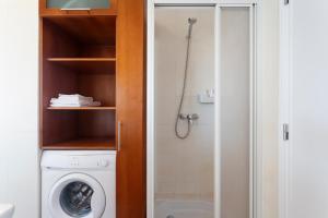 a bathroom with a washing machine and a shower at Beach House Cascais in Estoril
