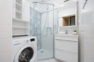 a white bathroom with a washing machine and a shower at Sienna Cosy & Family Apartment Warsaw Center by Renters in Warsaw