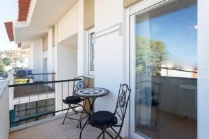 a balcony with two chairs and a table at Beach House Cascais in Estoril