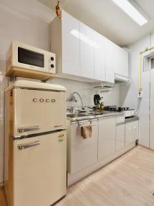 a kitchen with white appliances and a microwave at Juin - Foreigner only in Seoul