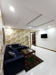 sala de estar con sofá azul y mesa en 501-NEXT INN Cozy apartment for your stay.., en Lahore