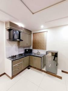una cocina con electrodomésticos de acero inoxidable en una habitación en 501-NEXT INN Cozy apartment for your stay.., en Lahore
