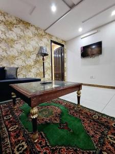 una sala de estar con una mesa de madera sobre una alfombra en 501-NEXT INN Cozy apartment for your stay.., en Lahore